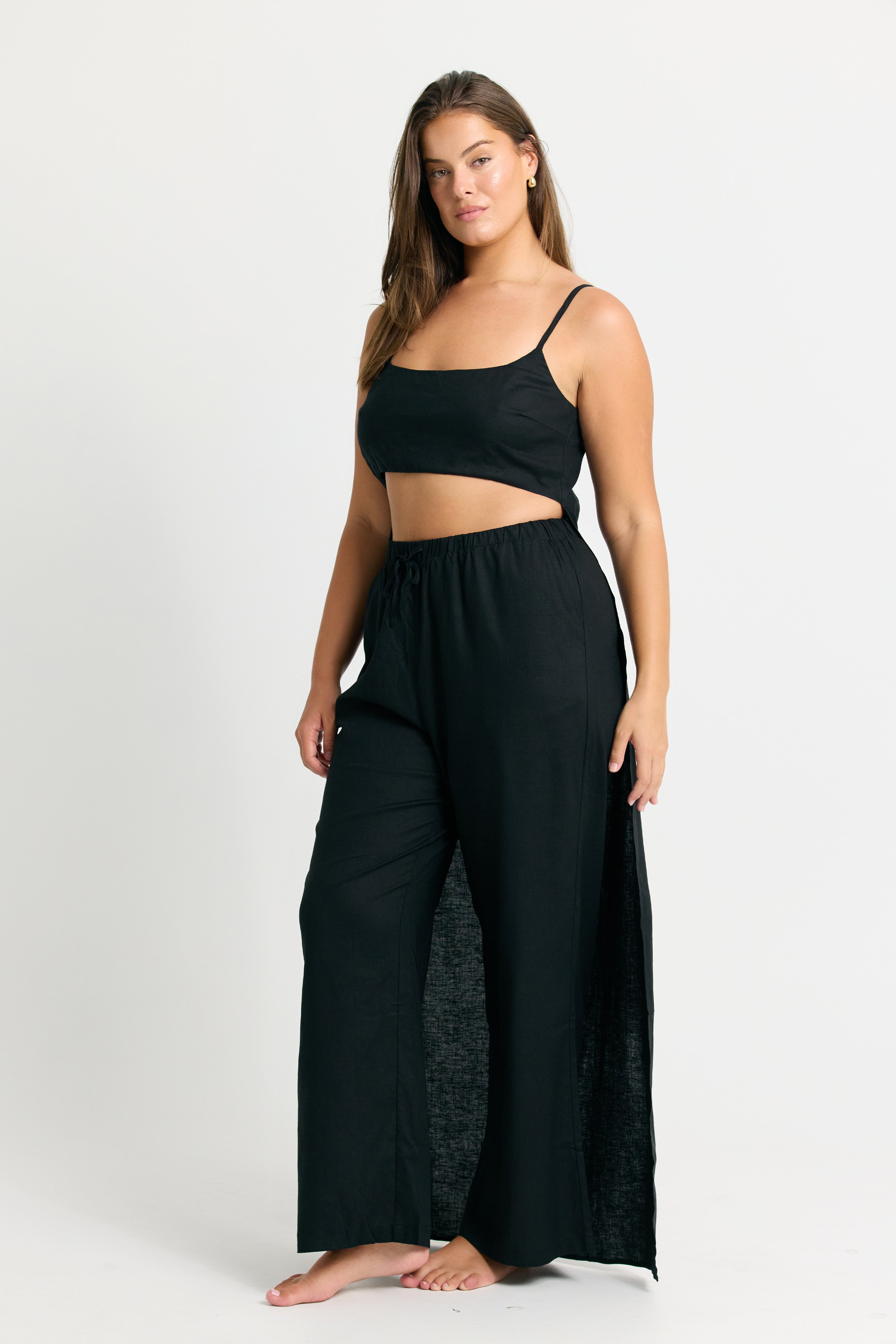 Woman wearing a Black Linen Crop Top with Train Back and wide-leg pants on a white background