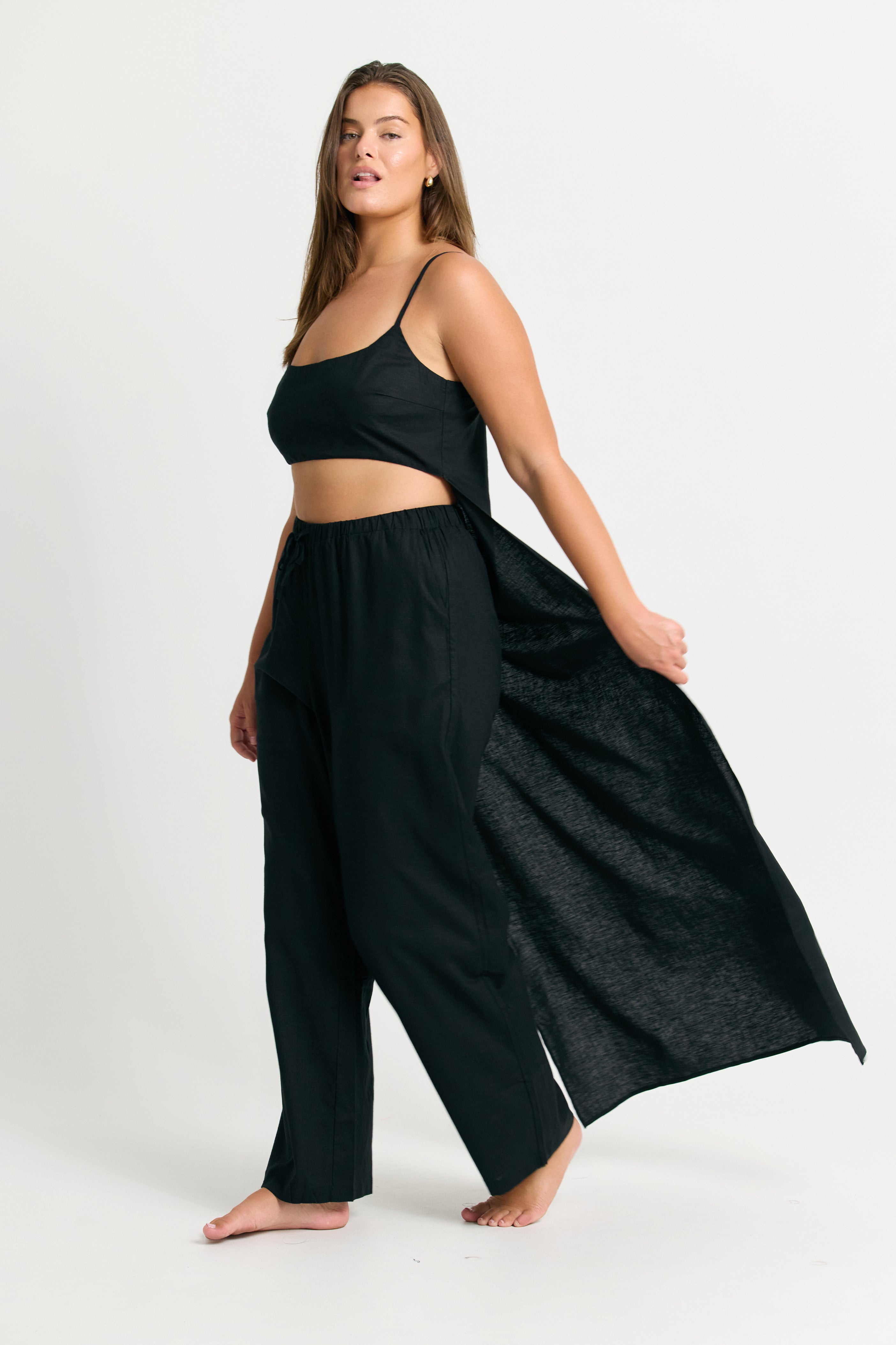 Woman wearing a Black Linen Crop Top with Train Back and wide-leg pants on a white background