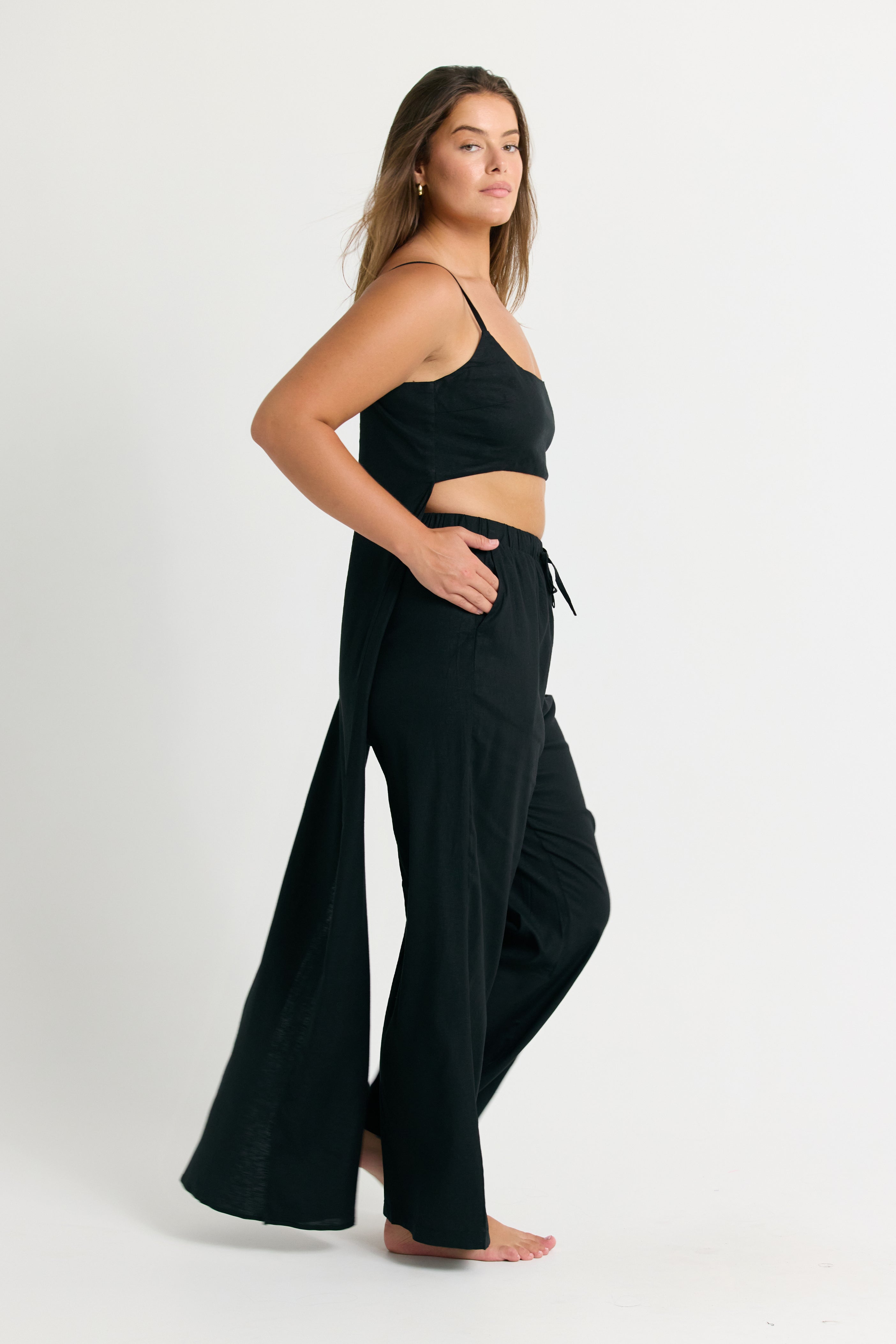 Woman wearing a Black Linen Crop Top with Train Back and wide-leg pants on a white background