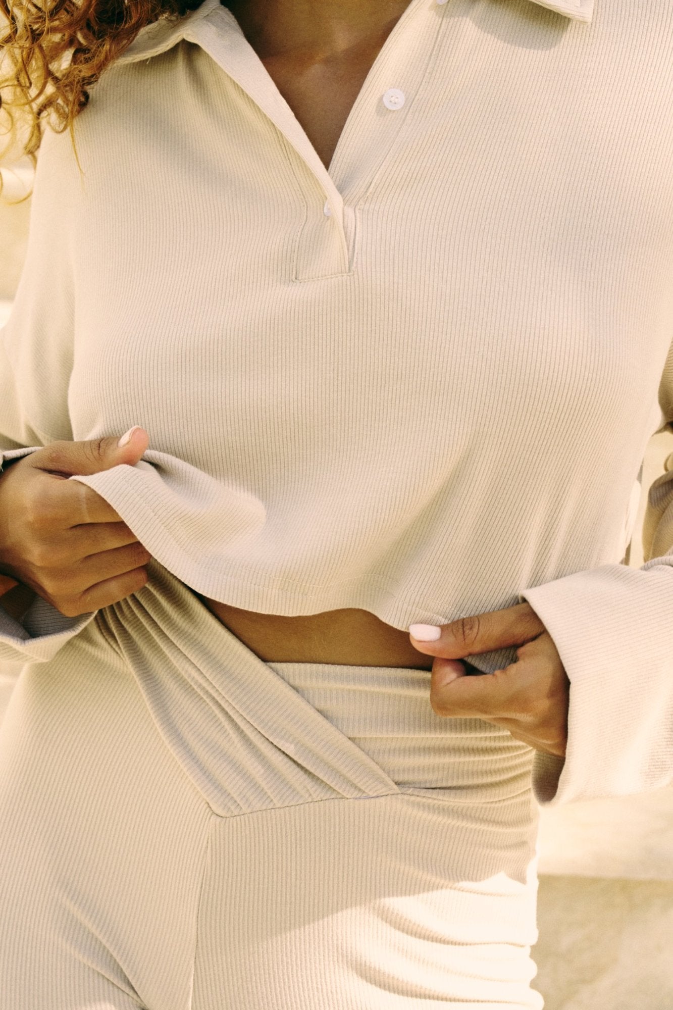 Close-up of a person wearing a beige/coconut shirt with a focus on the fabric texture.