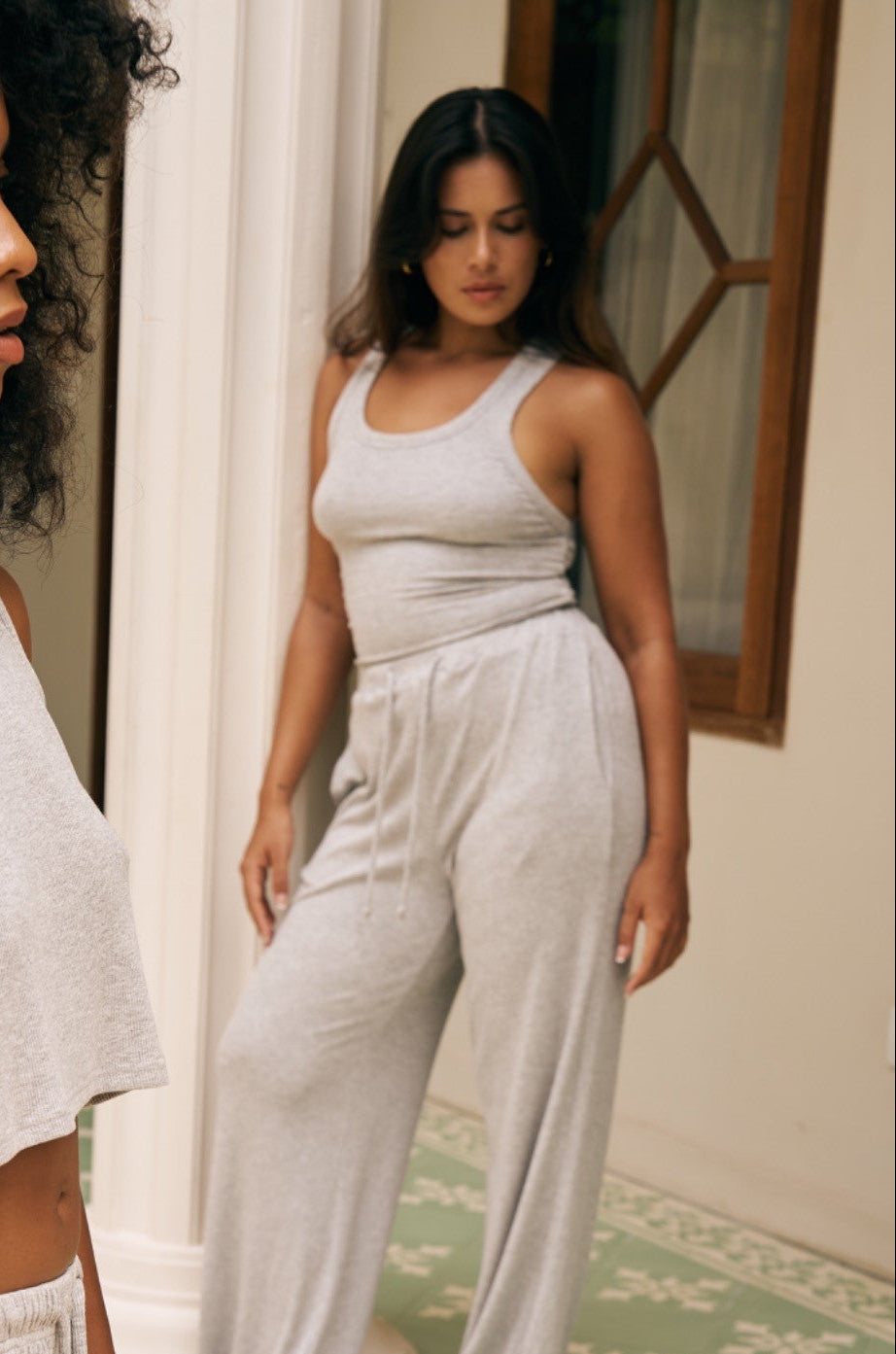 Woman in a light gray tank and pants standing next to a Pilar 