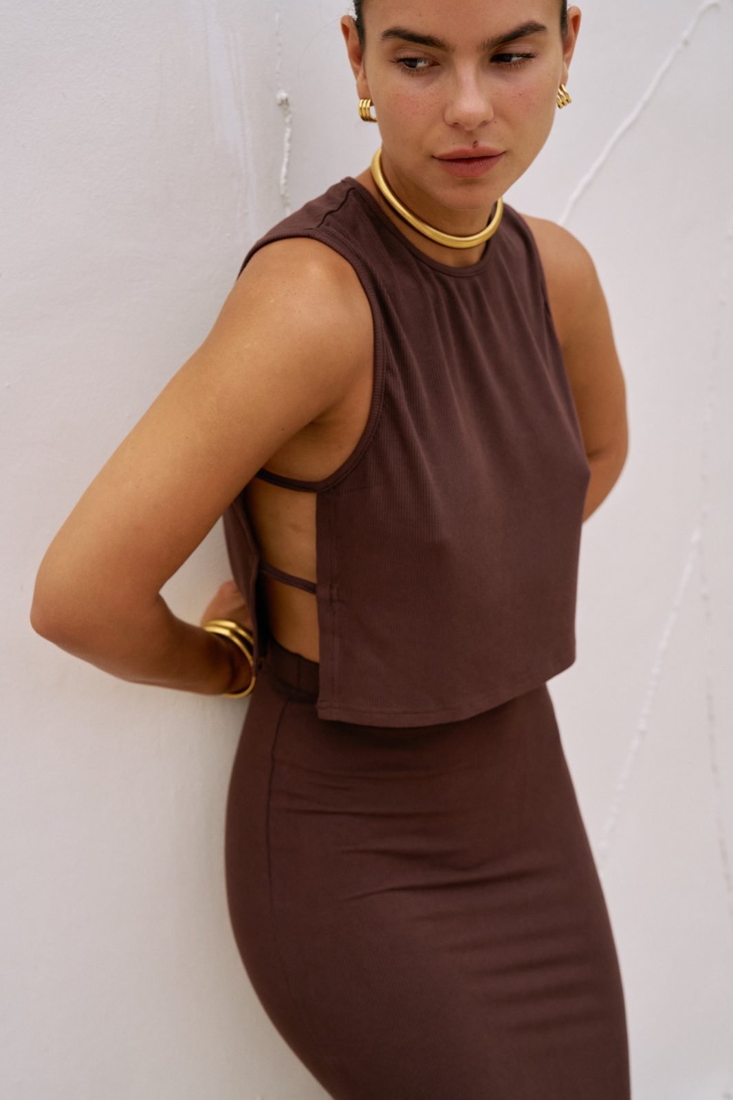 Side view detail of the chocolate brown Simi top with side straps paired with the Dom maxi skirt.
